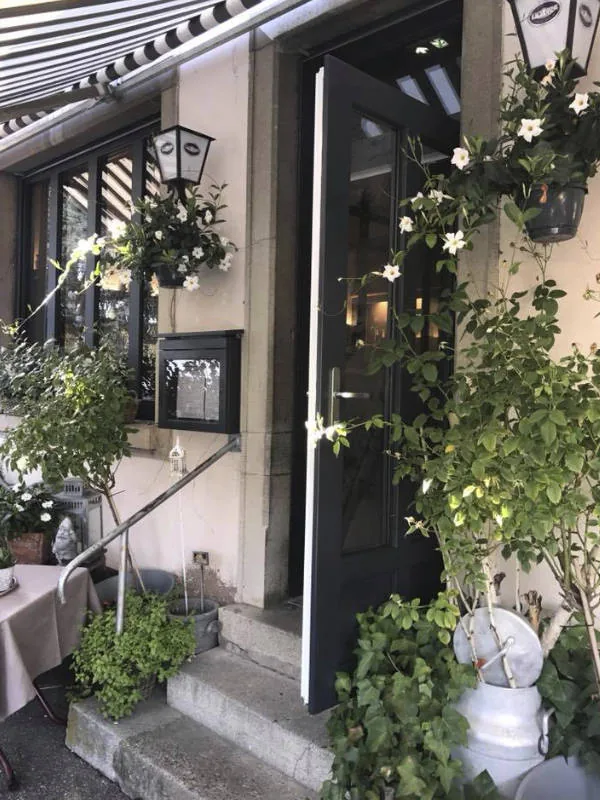 L'entrée du restaurant, porte vitrée et plantes grimpantes